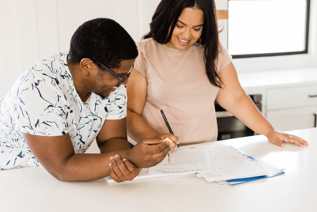 Happy Couple Signing Paperwork for New Home